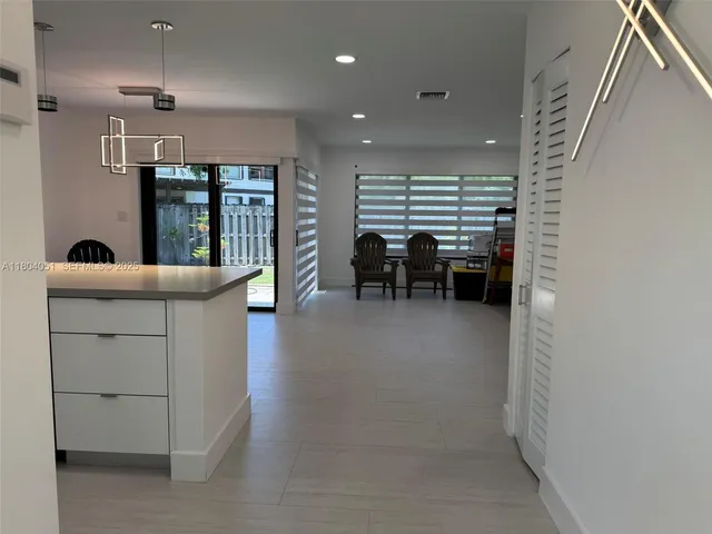 a kitchen that has a lot of cabinets in it and wooden floor
