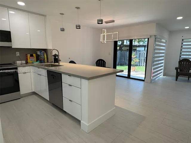 a kitchen with sink a refrigerator and cabinets