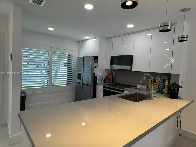 a kitchen with stainless steel appliances granite countertop a sink a stove and a refrigerator