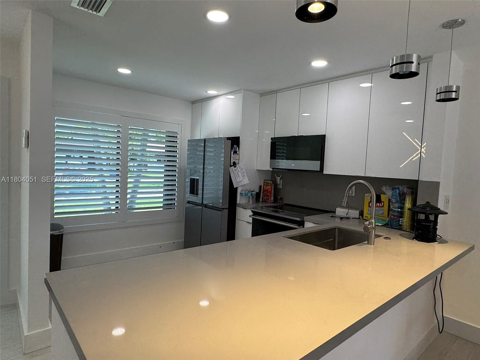 12721 Southwest 68th Terrace Miami, FL 33183 - Photo 6 of 31 a kitchen with sink a refrigerator and cabinets
