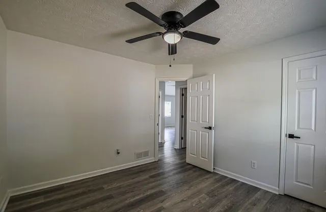 a bathroom with a granite countertop sink a toilet and a window