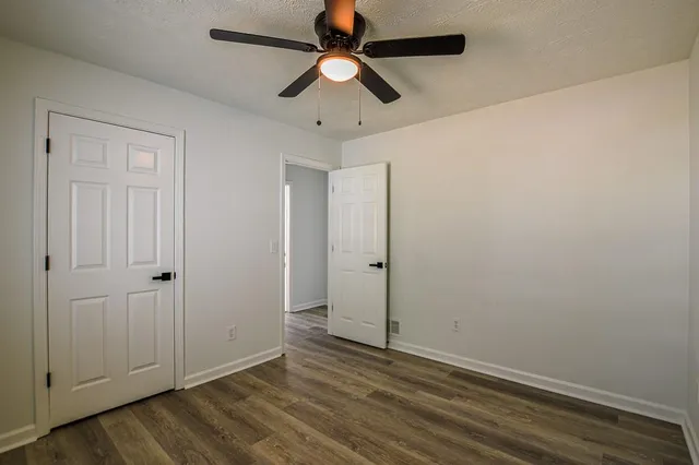 an empty room with a window and a ceiling fan
