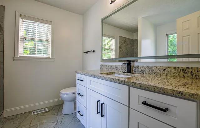 a bathroom with a granite countertop sink and a mirror
