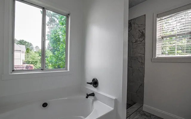 an empty room with wooden floor and hallway