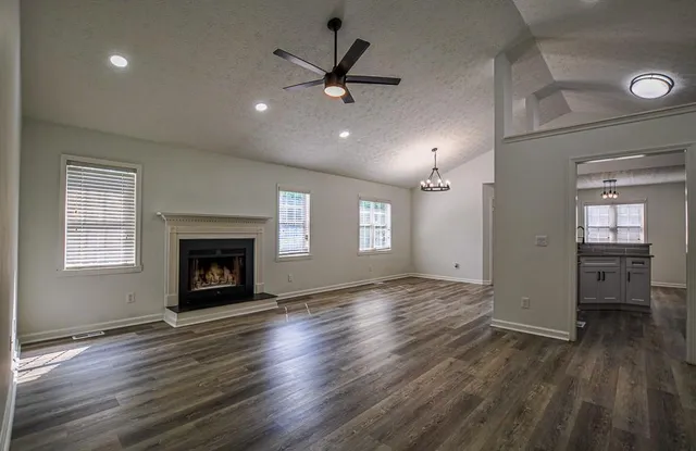 an empty room with wooden floor and ceiling fan
