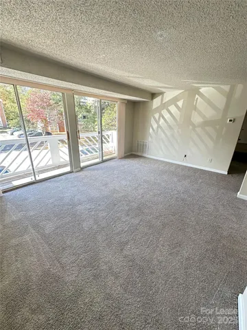 an empty room with windows and city view