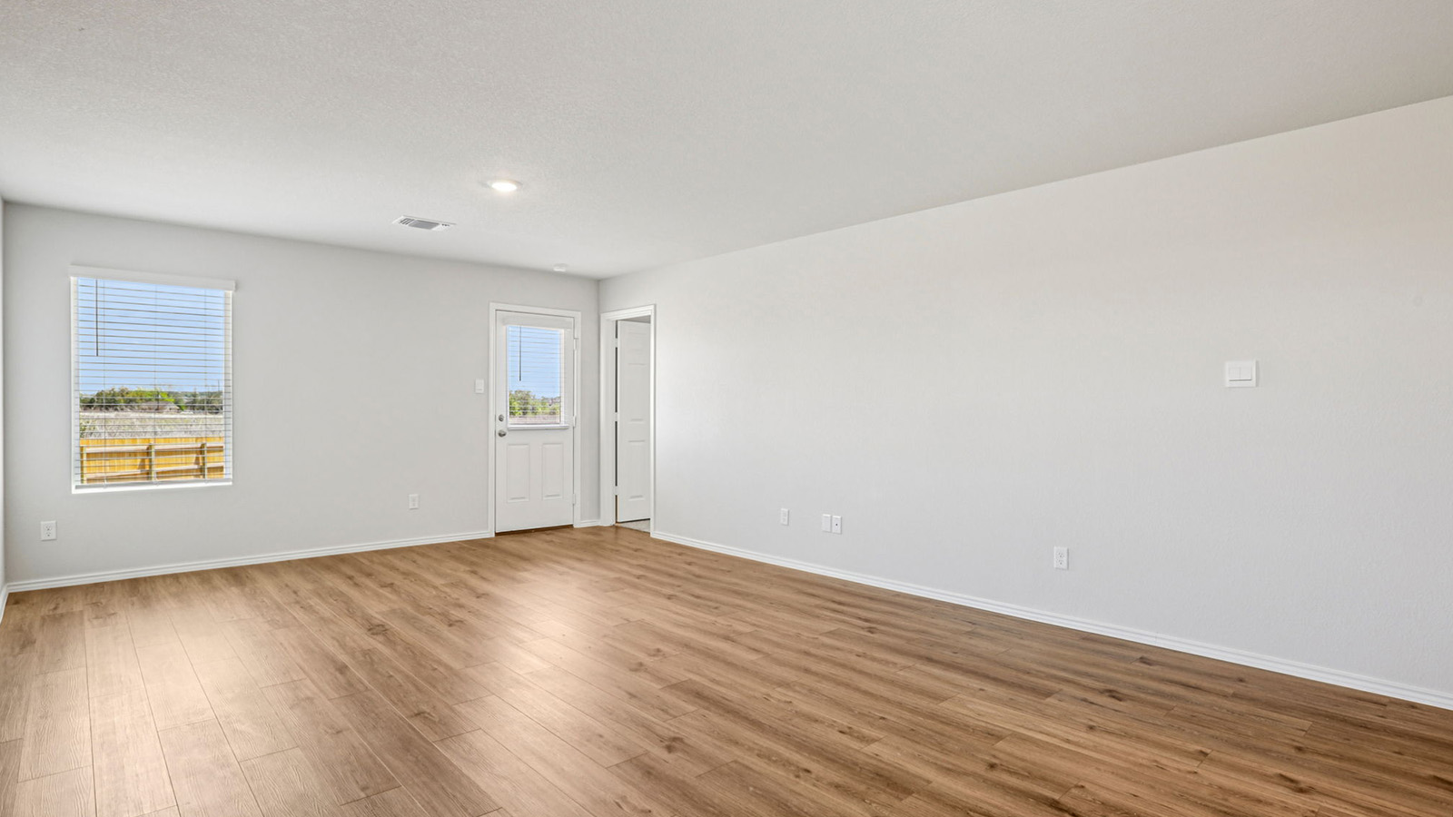 148 Wyatt Way Jarrell, TX 76537 - Photo 13 of 33 Spacious interior room featuring wood-finish flooring, light-toned walls, a window with blinds, and a door with a glass pane