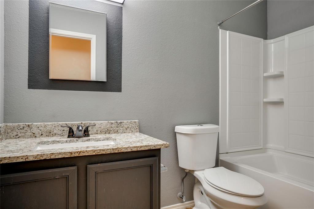 3054 Fallbrook Drive Rockwall, TX 75032 - Photo 14 of 15 a bathroom with a granite countertop toilet sink and mirror