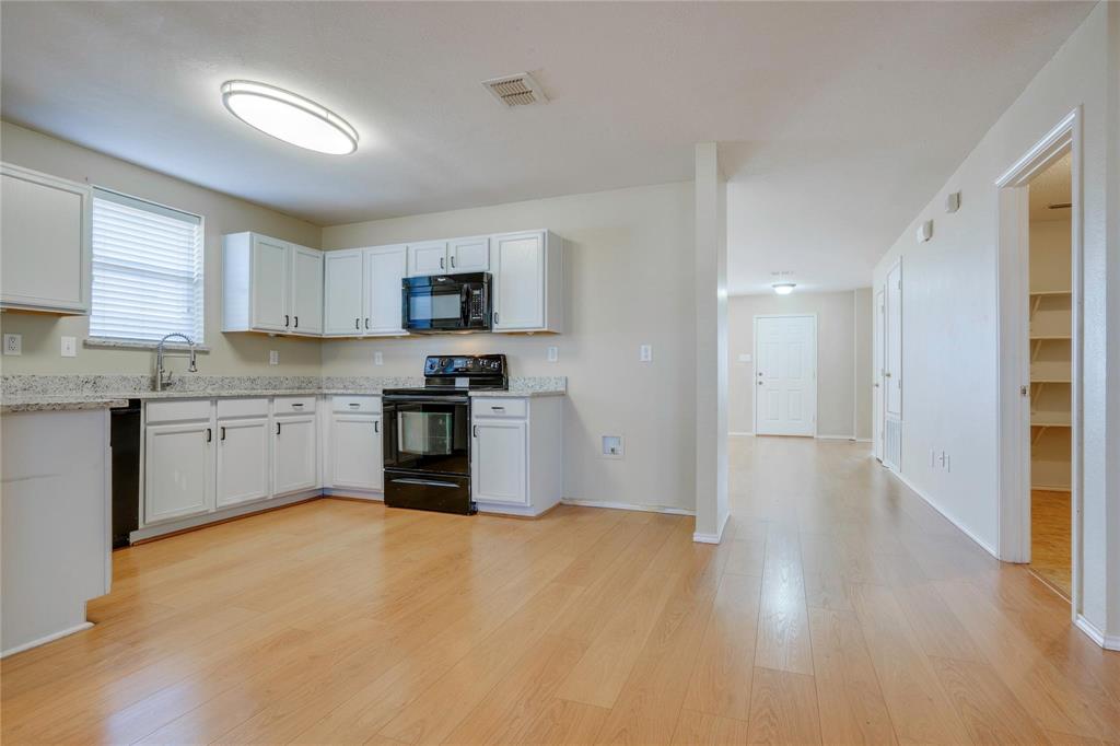 3054 Fallbrook Drive Rockwall, TX 75032 - Photo 6 of 15 a kitchen with granite countertop white cabinets and stainless steel appliances