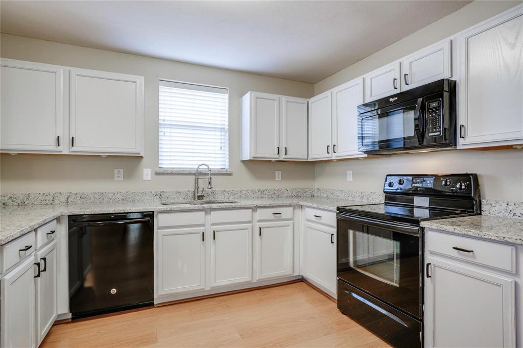 3054 Fallbrook Drive Rockwall, TX 75032 - Photo 7 of 15 a kitchen with stainless steel appliances granite countertop white cabinets granite counter tops and a window