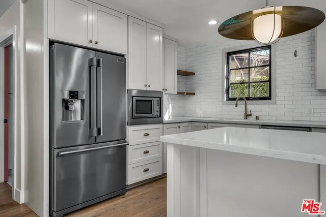 a kitchen with stainless steel appliances a refrigerator sink and cabinets