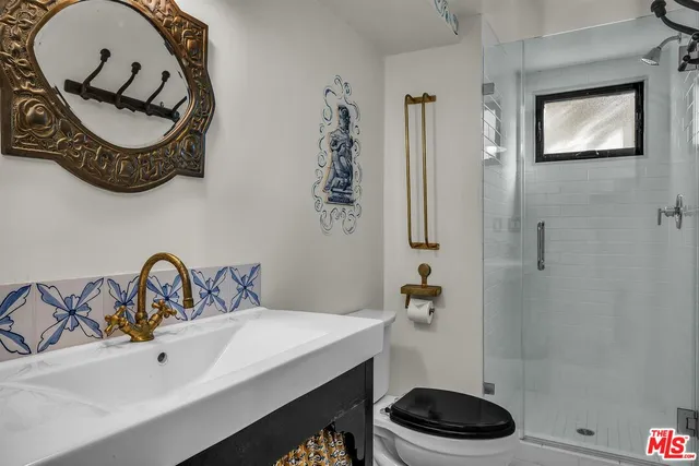 a bathroom with a sink a toilet and a mirror