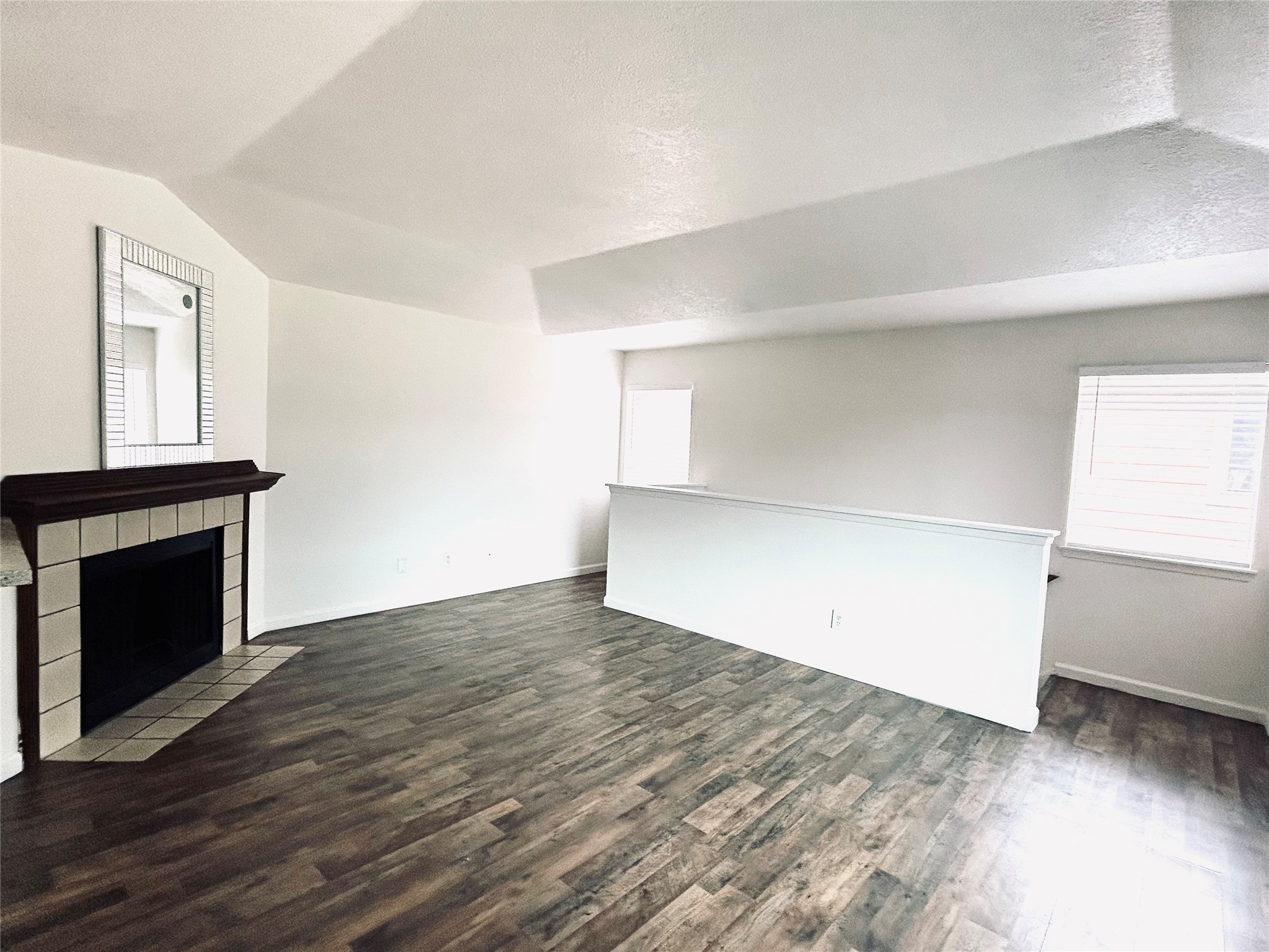 8030 Sands Point Drive, Unit D Houston, TX 77036 - Photo 2 of 14 an empty room with wooden floor fireplace and windows