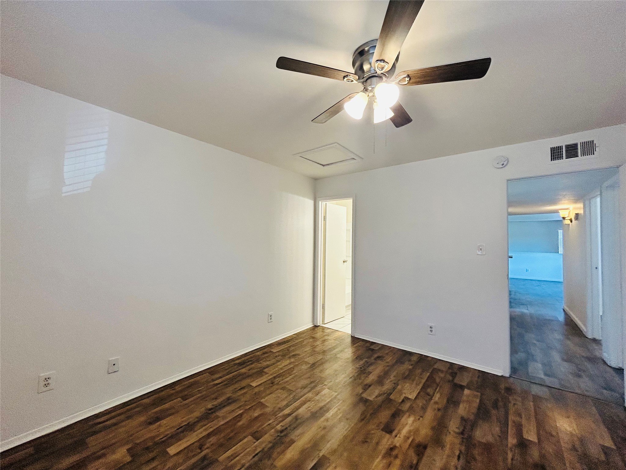 8030 Sands Point Drive, Unit D Houston, TX 77036 - Photo 10 of 24 an empty room with wooden floor fan and windows