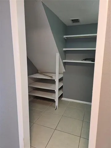 a view of walk in closet with empty racks