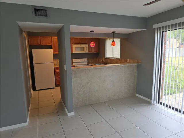 a view of kitchen with refrigerator and window