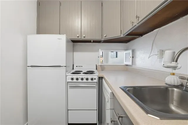 a kitchen with cabinets appliances and a sink