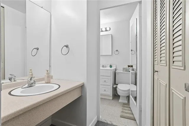 a bathroom with a sink toilet and a mirror