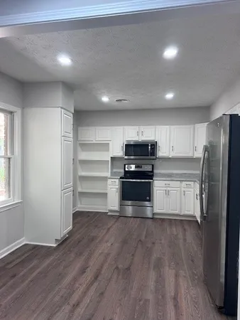 a kitchen with a refrigerator and a stove top oven