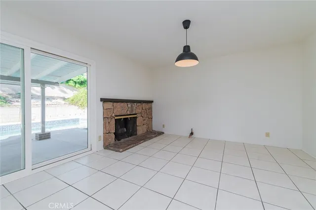 an empty room with fireplace and windows