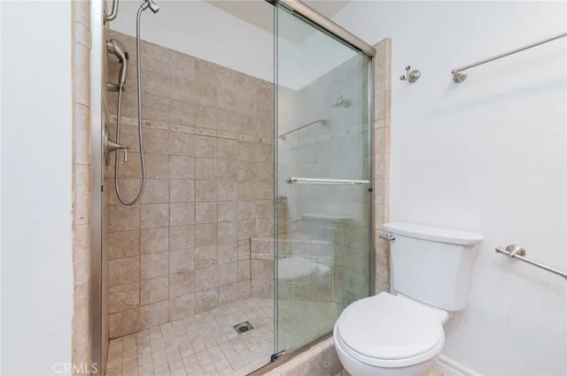 a white toilet next to a bathroom