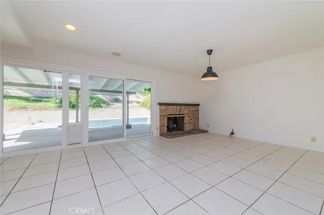 a view of an empty room with a fireplace and a window