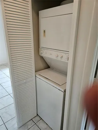 a view of an empty room with wooden floor and closet