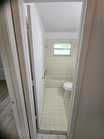 a view of an empty room with wooden floor and closet