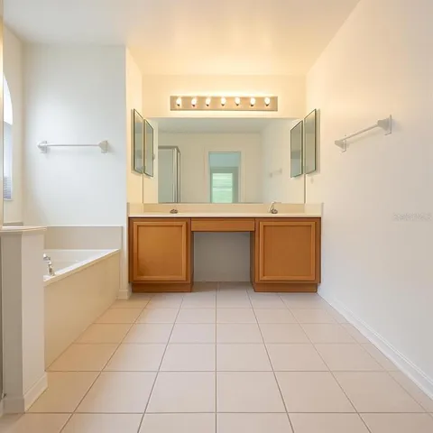 a white bath tub sitting next to a white sink and vanity