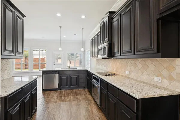 a kitchen with a sink dishwasher a stove and a refrigerator with wooden floor