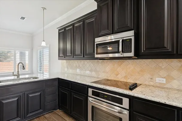 a kitchen with granite countertop cabinets stainless steel appliances and a sink