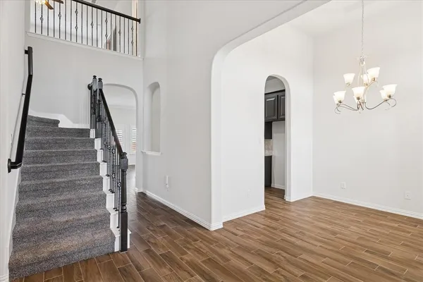 a view of a hallway with wooden floor and staircase