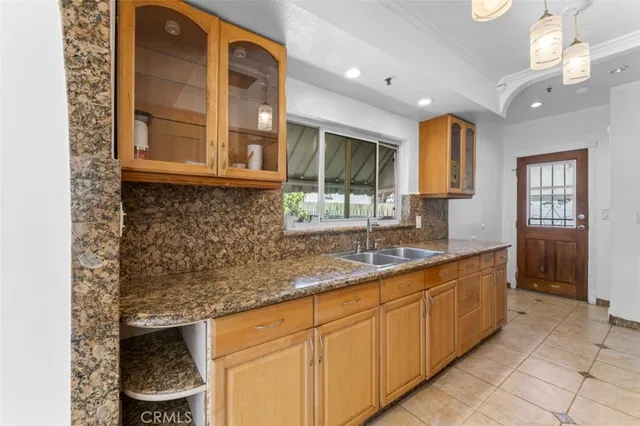 a kitchen with granite countertop a sink and cabinets