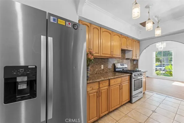 a kitchen with stainless steel appliances granite countertop a stove a refrigerator and a sink