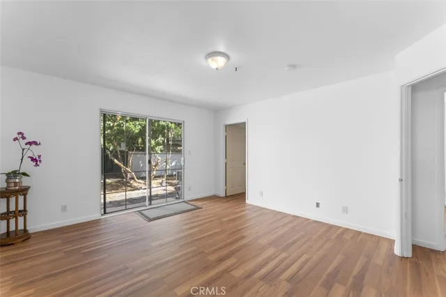 an empty room with wooden floor and outdoor view