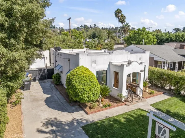 an aerial view of a house with a yard and potted plants