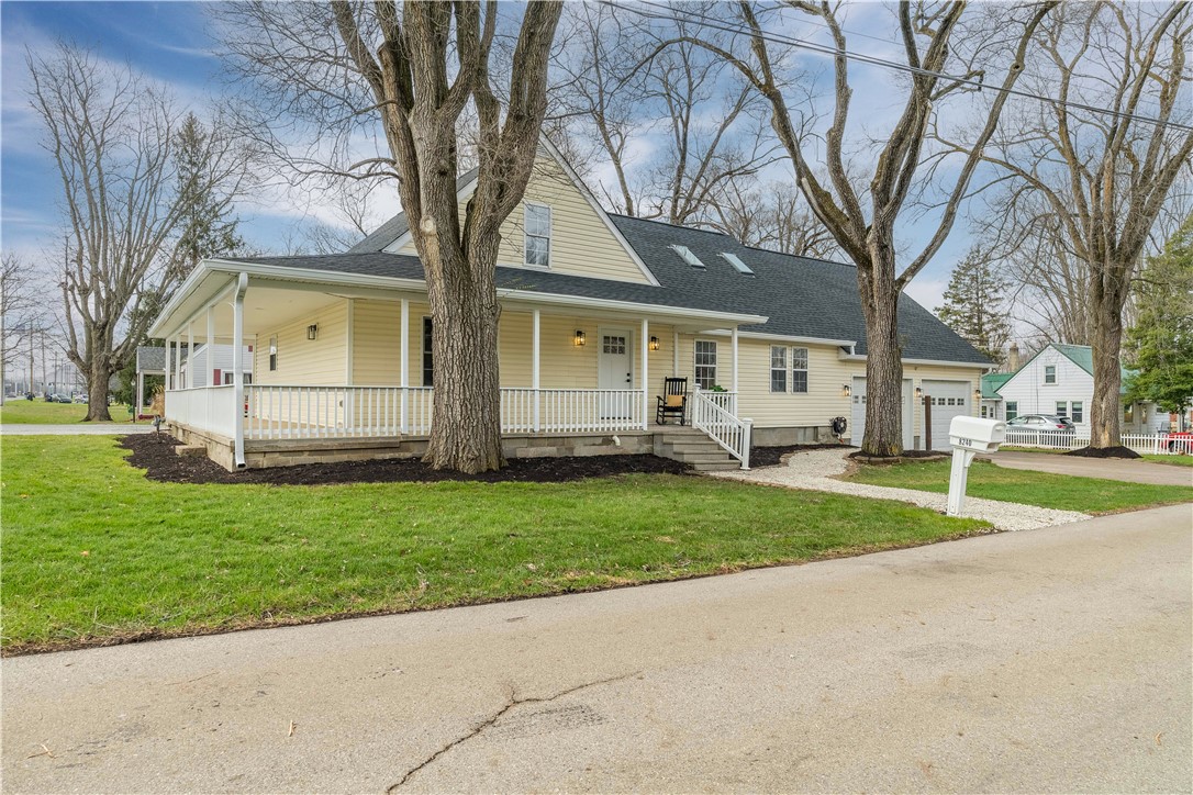8240 Looney Road Piqua, OH 45356 - Photo 2 of 49 This charming home features a welcoming porch, lush lawn, and attached garage.