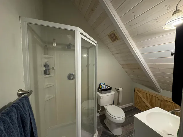 a white toilet sitting next to a bathroom sink and a mirror