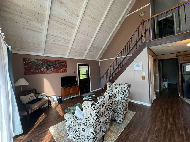 a living room with furniture floor to ceiling window and wooden floor