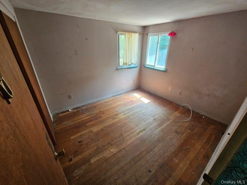 51 Shore Road Hampton Bays, NY 11946 - Photo 7 of 19 a view of an empty room with wooden floor and a window