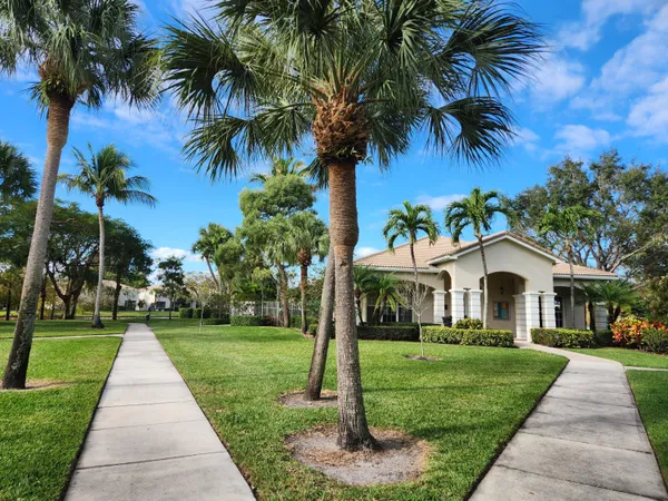 a front view of a house with a garden and trees