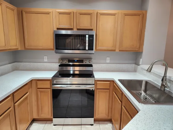 a kitchen with stainless steel appliances granite countertop a sink stove and microwave