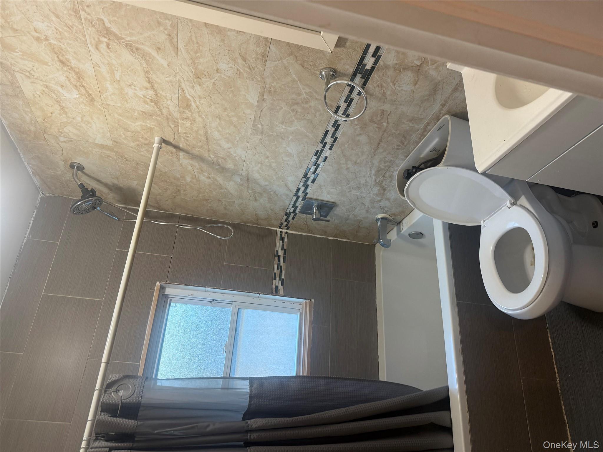 28 Clinton Avenue, Unit 2 Hempstead, NY 11096 - Photo 4 of 5 a bathroom with a sink a toilet a mirror and a bathtub