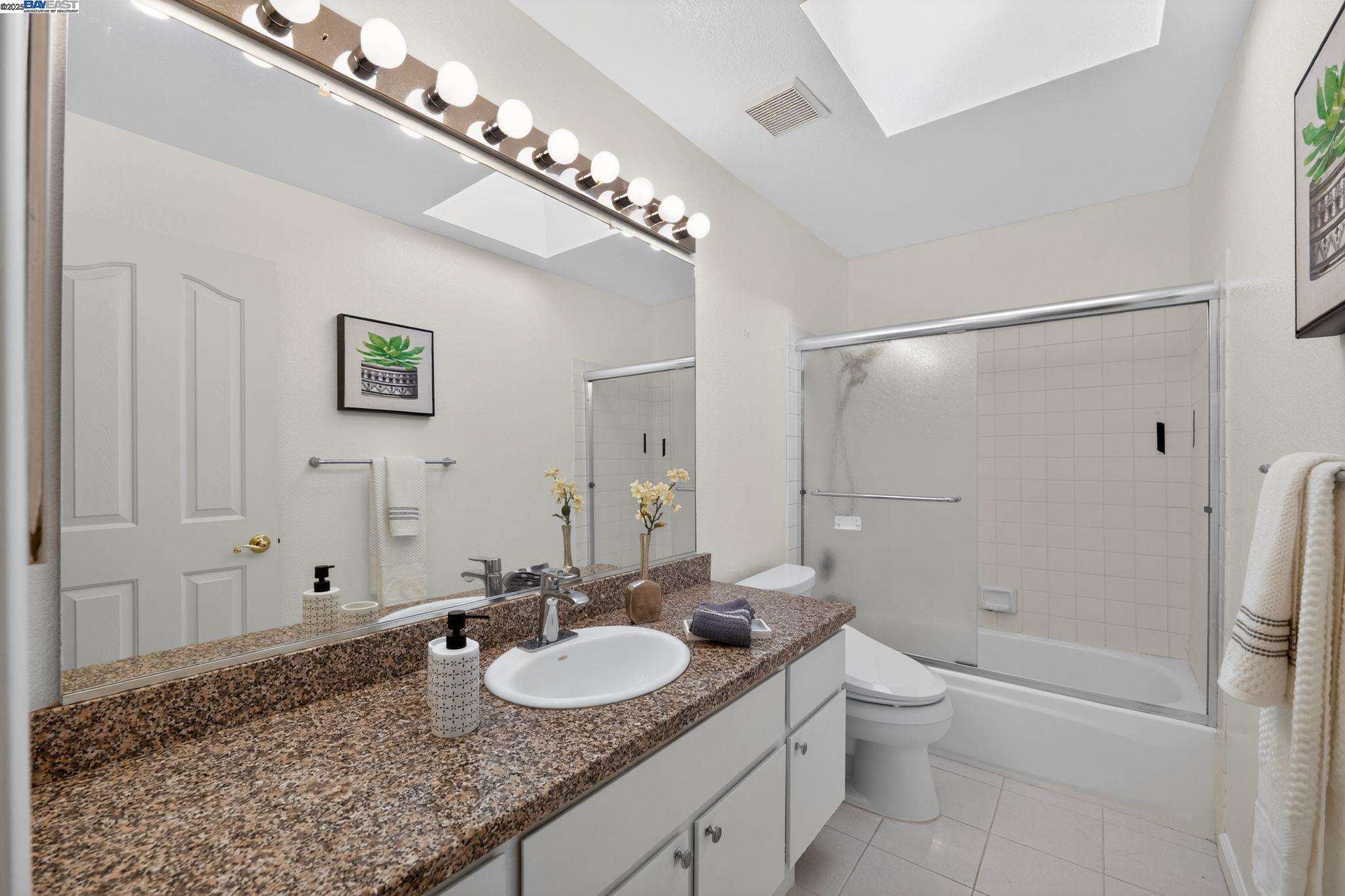 7210 Valley View Court Pleasanton, CA 94588 - Photo 22 of 44 a bathroom with a granite countertop sink a toilet and shower