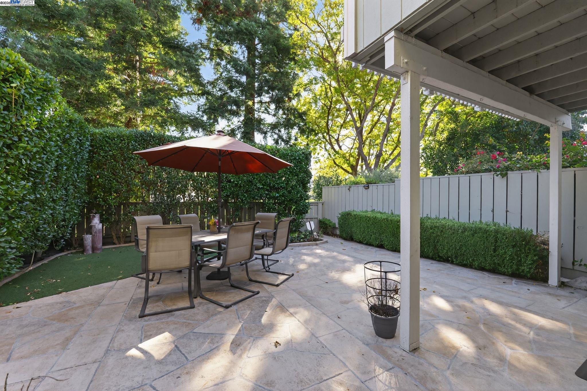 7210 Valley View Court Pleasanton, CA 94588 - Photo 34 of 44 a view of a patio with a table and chairs under an umbrella with a small yard