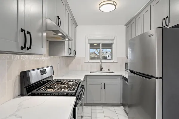 a kitchen with stainless steel appliances a stove and a sink