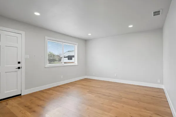 a view of room with window and wooden floor