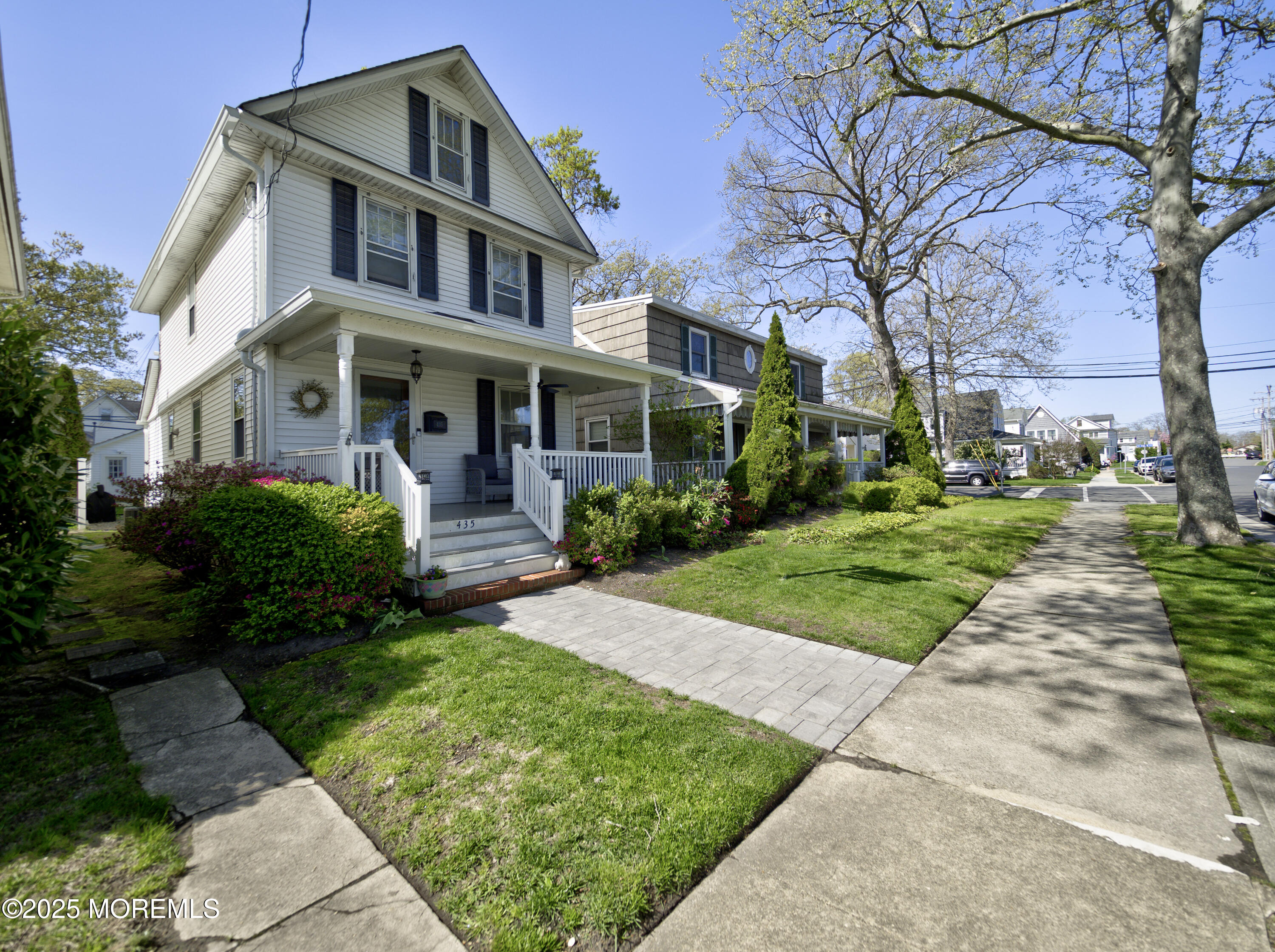 a front view of a house with a garden and trees