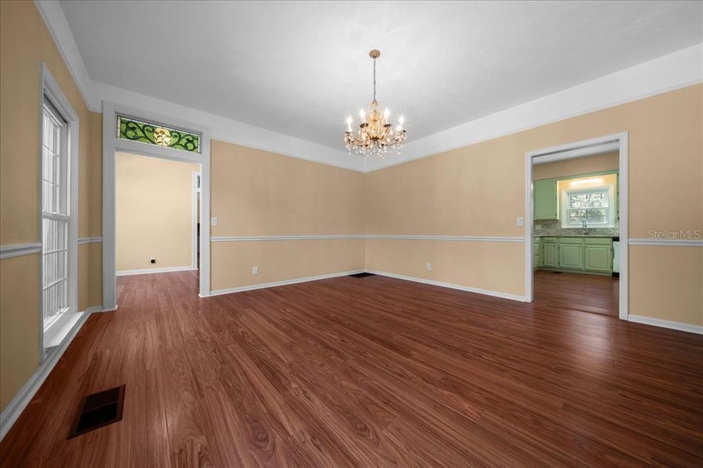 7808 Northeast 75th Street Gainesville, FL 32609 - Photo 16 of 78 an empty room with wooden floor chandelier and windows