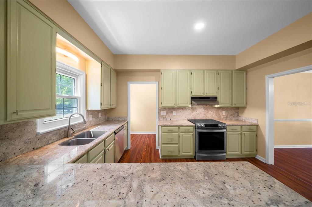 7808 Northeast 75th Street Gainesville, FL 32609 - Photo 20 of 78 a kitchen with stainless steel appliances granite countertop a sink stove and refrigerator